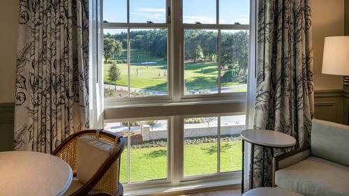 Work table & lounge area by a window in Golf View King Room at Camp Creek Inn