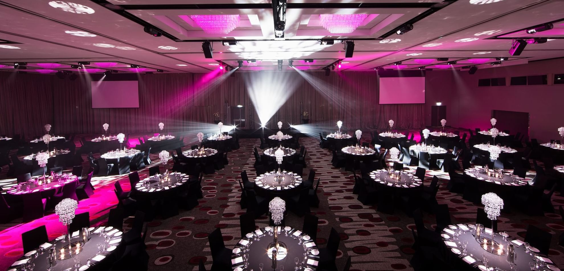 Banquet set-up in illuminated Grand Ballroom with carpeted floors at Pullman Albert Park