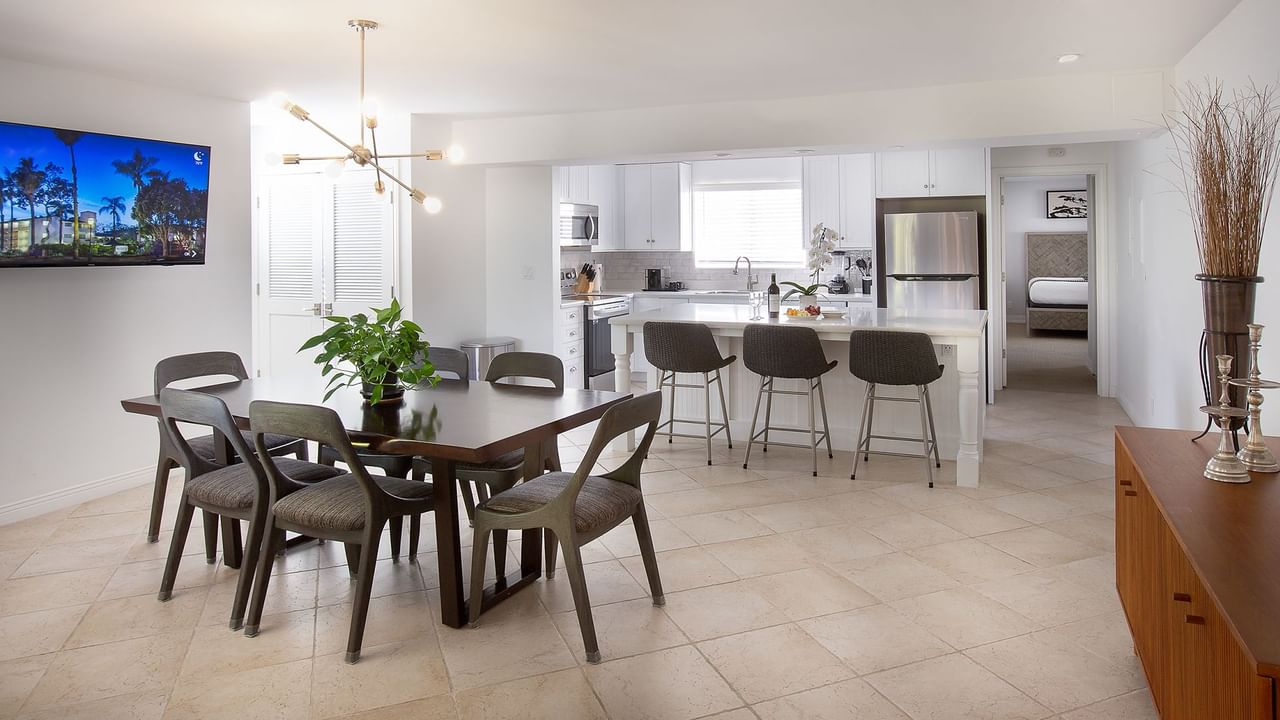 A kitchen and dining room featuring a flat screen TV and full kitchen