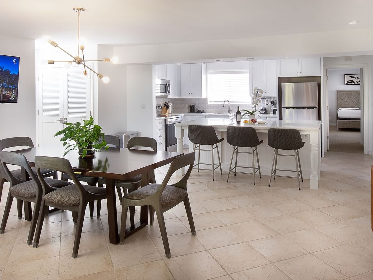 A kitchen and dining room featuring a flat screen TV and full kitchen