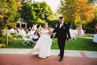 Bride and groom holding hands in gazebo garden