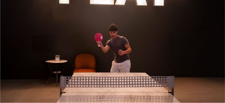Person holding paddle during an indoor table tennis match in Level Up - Indoor Gaming Hub at DAMAC Maison Aykon City