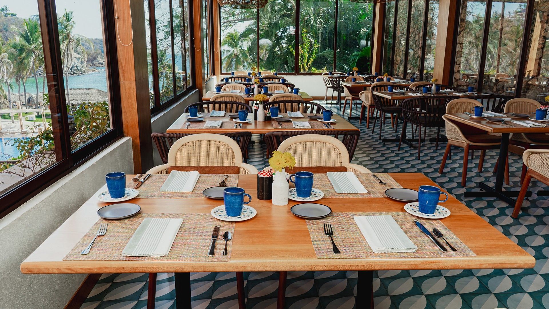 Bright, airy dining area with large windows showcasing a tropical view in Chez Binni at Camino Real Zaashila Huatulco