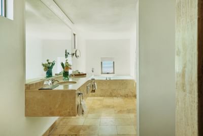 A luxurious bathroom with a large tub, marble counter, and tiled floor.