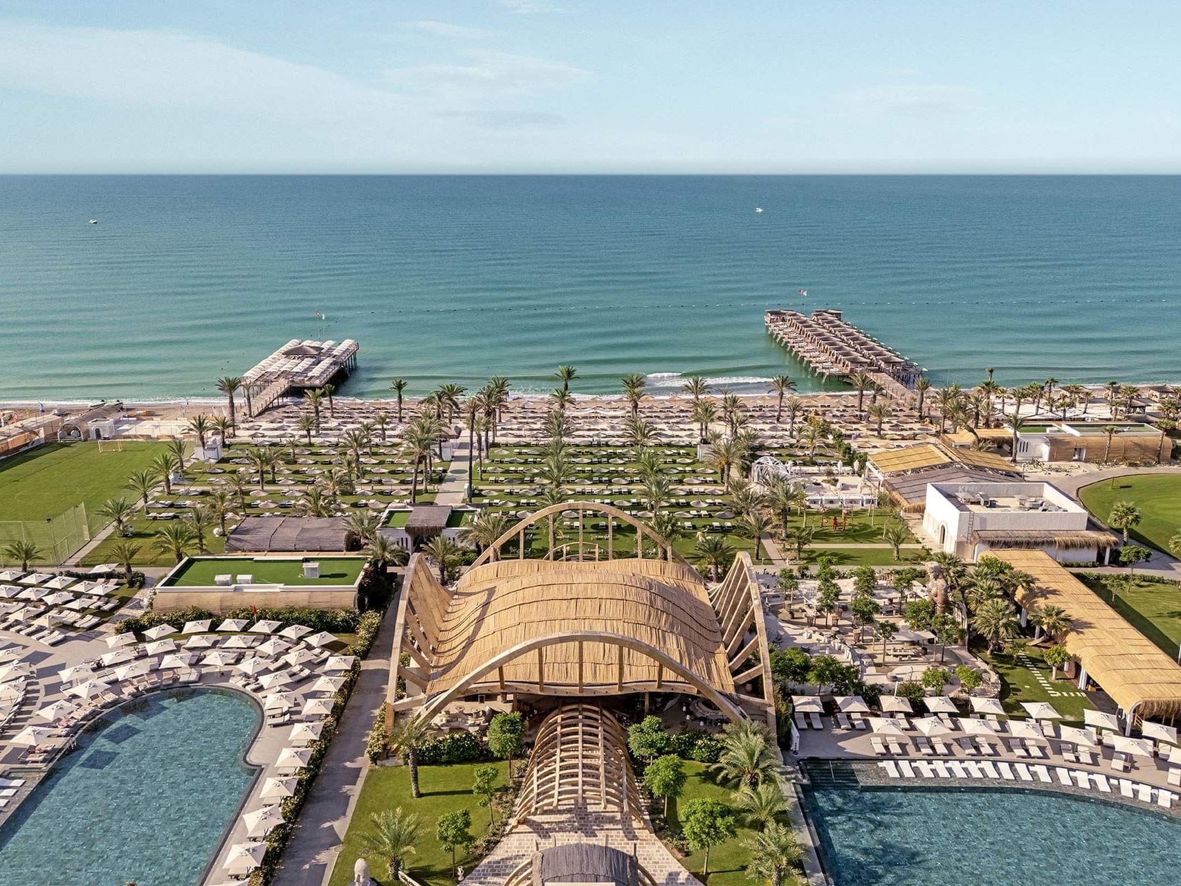 Aerial view of a large resort with pools, cabanas, and beach access by the ocean Cullinan Belek.
