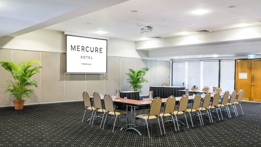 Burdekin Room with u-shape table setup, chairs and projector screen at Mercure Hotel Townsville