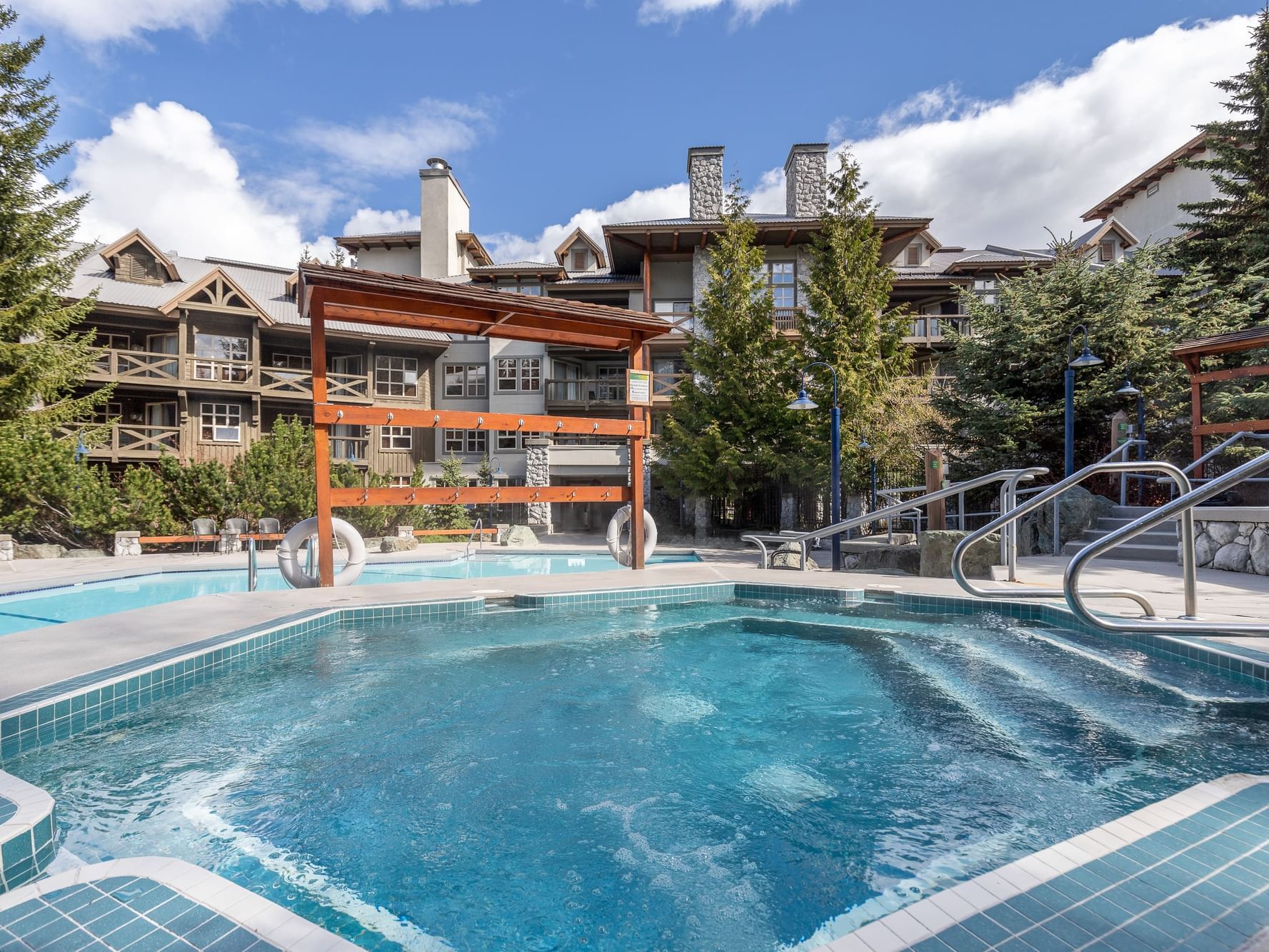 Outdoor heated pool in the wet area by hotel exterior at Blackcomb Springs Suites