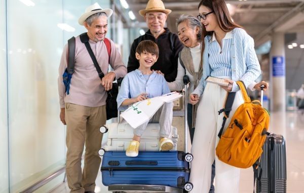 Asian multigenerational family at airport traveling with kids and grandparents, joyful moments of vacation, family holiday trip with luggage before flight, tour, friendly airline, hotel for families.