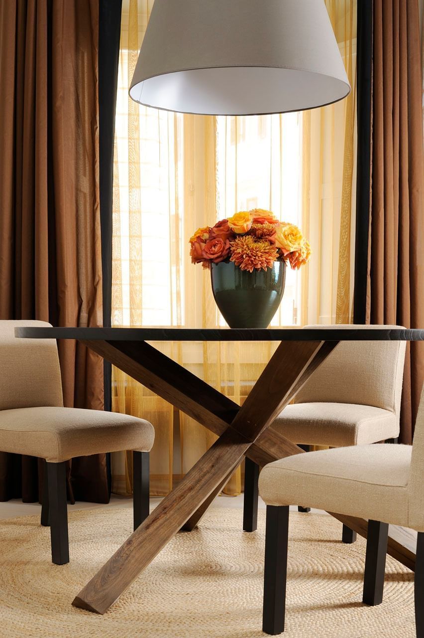 Dining table with chairs and vase of flowers in Deluxe Suite at Babuino 181