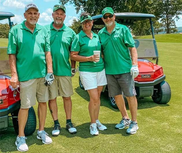 A Golf Group posing by a golf cart at Shangri-La Monkey Island