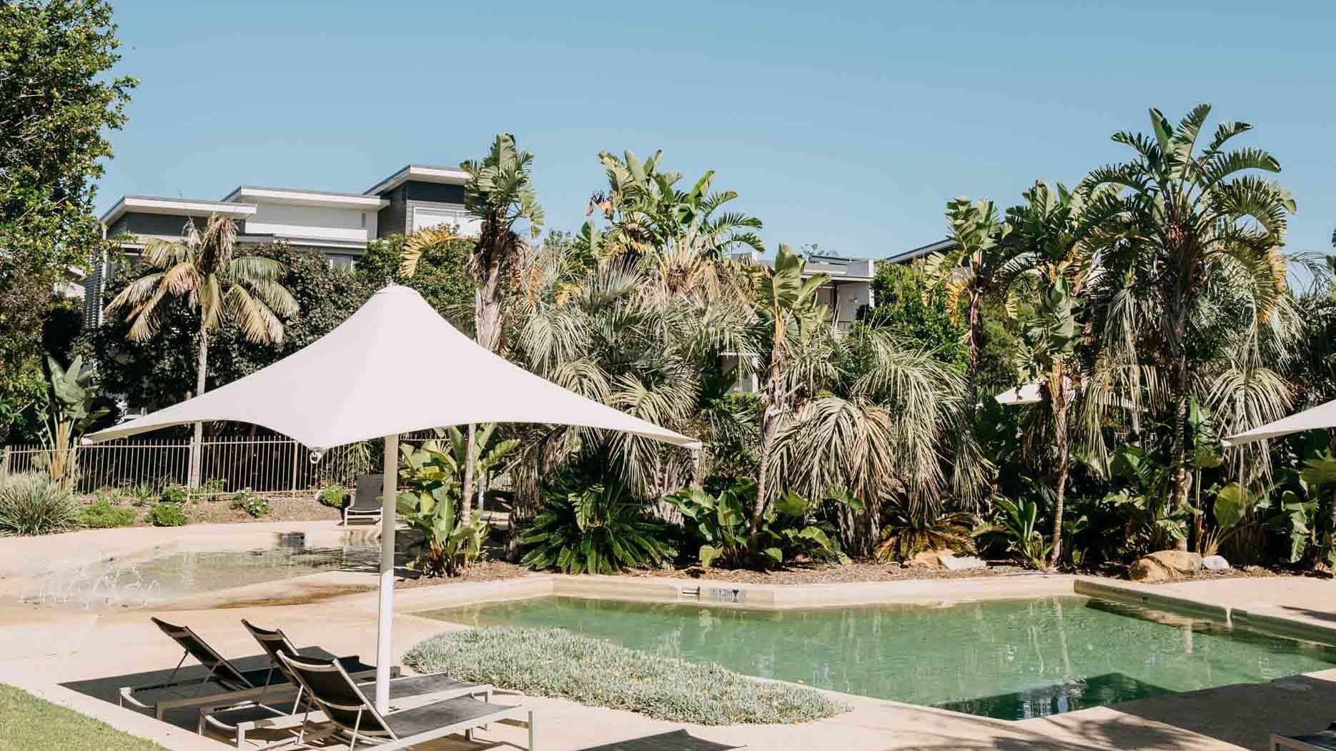 Outdoor Rock Pools with arranged sunbeds at Pullman Magenta Shores