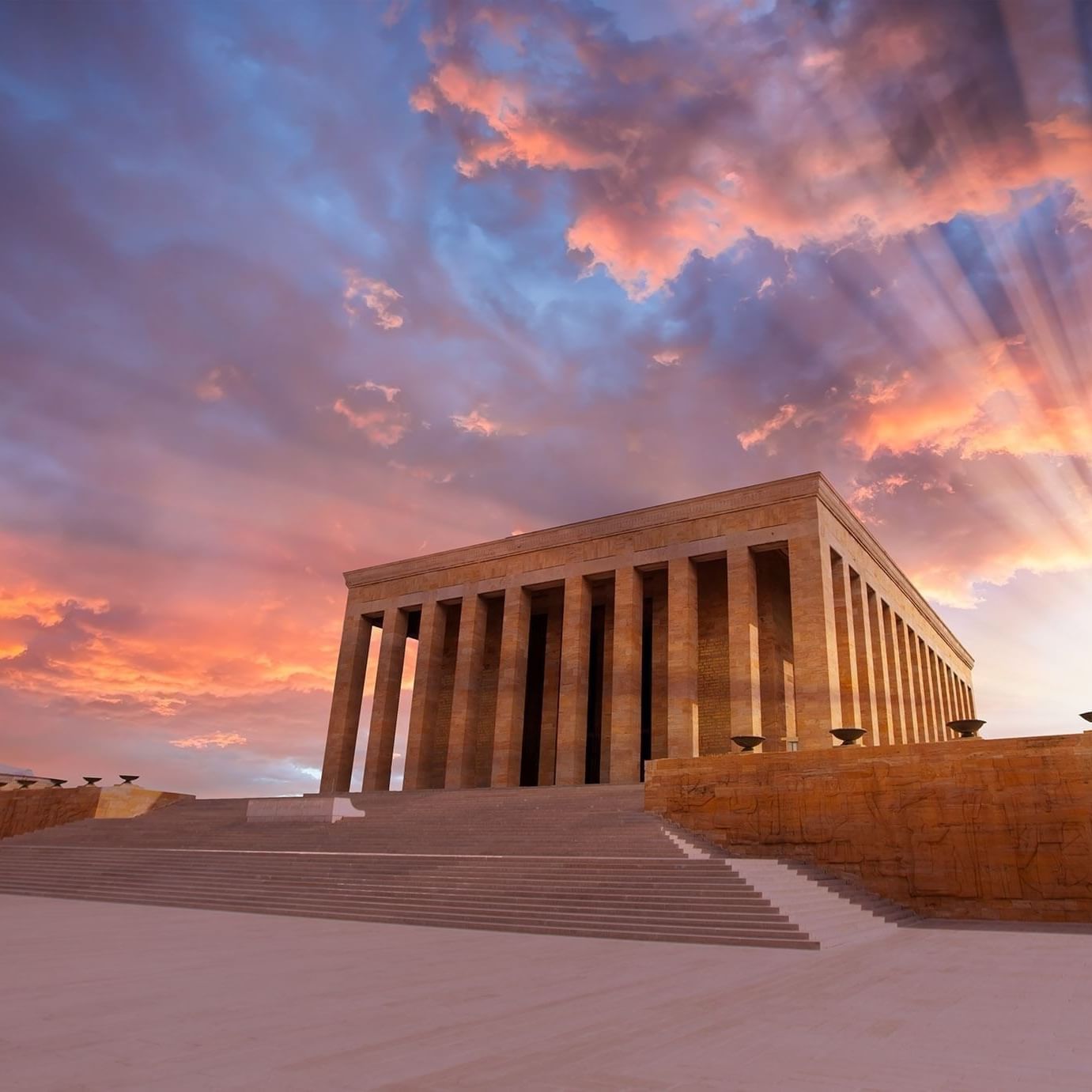 Entrance to Anitkabir Monument by wide steps under a dramatic sunset with sun rays near Warwick Ankara