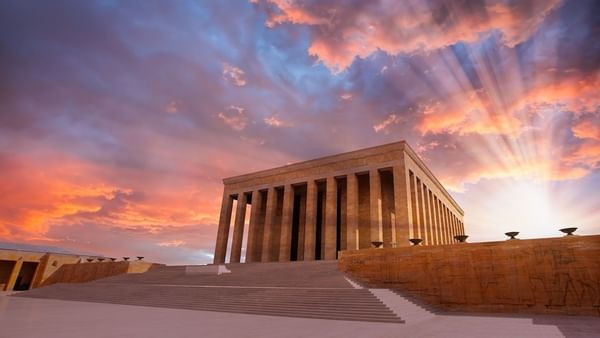 Entrance to Anitkabir Monument by wide steps under a dramatic sunset with sun rays near Warwick Ankara