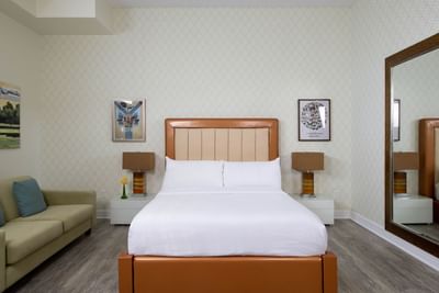 King bed, sofa & bedside lamps in Queen Premiere Spring Fling at Retro Suites Hotel
