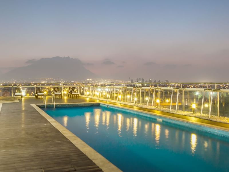 Rooftop swimming pool with warm lighting in Fiesta Inn