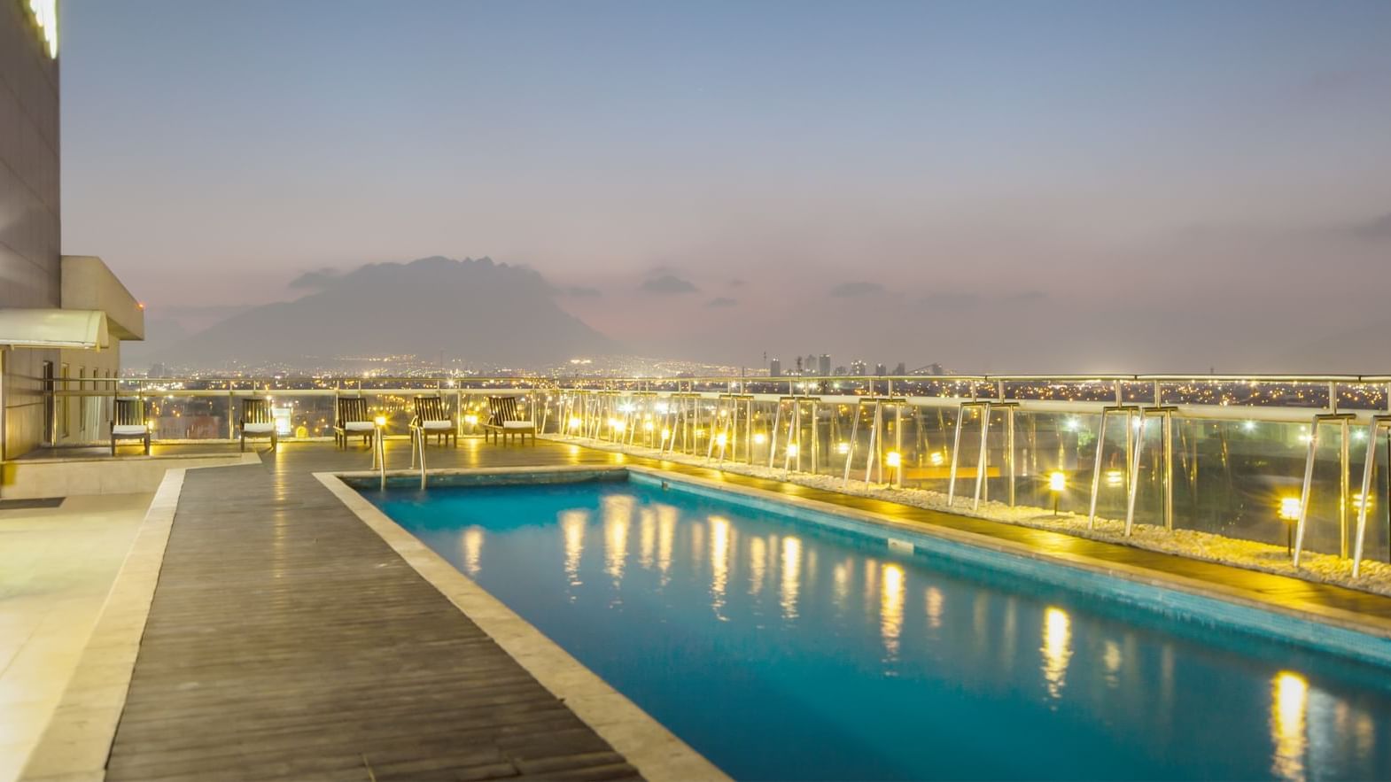 Outdoor pool with pool chairs at Fiesta Inn Monterrey Fundidora