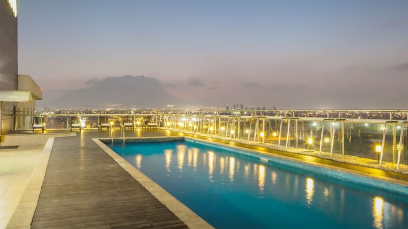 Outdoor pool with pool chairs at Fiesta Inn Monterrey Fundidora