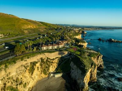 Aerial view of bluff and Pismo Preserve with green hills