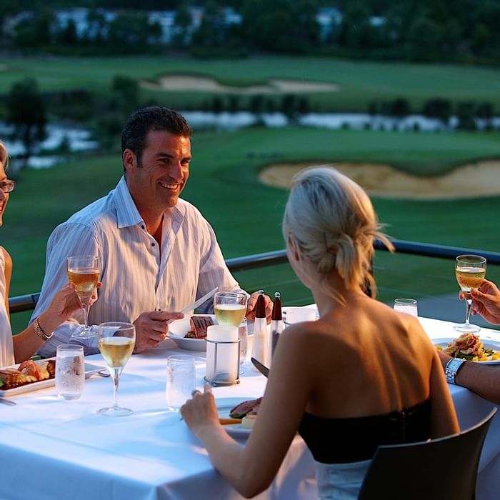 Four people having food in the balcony of Mercure Kooindah Waters hotel