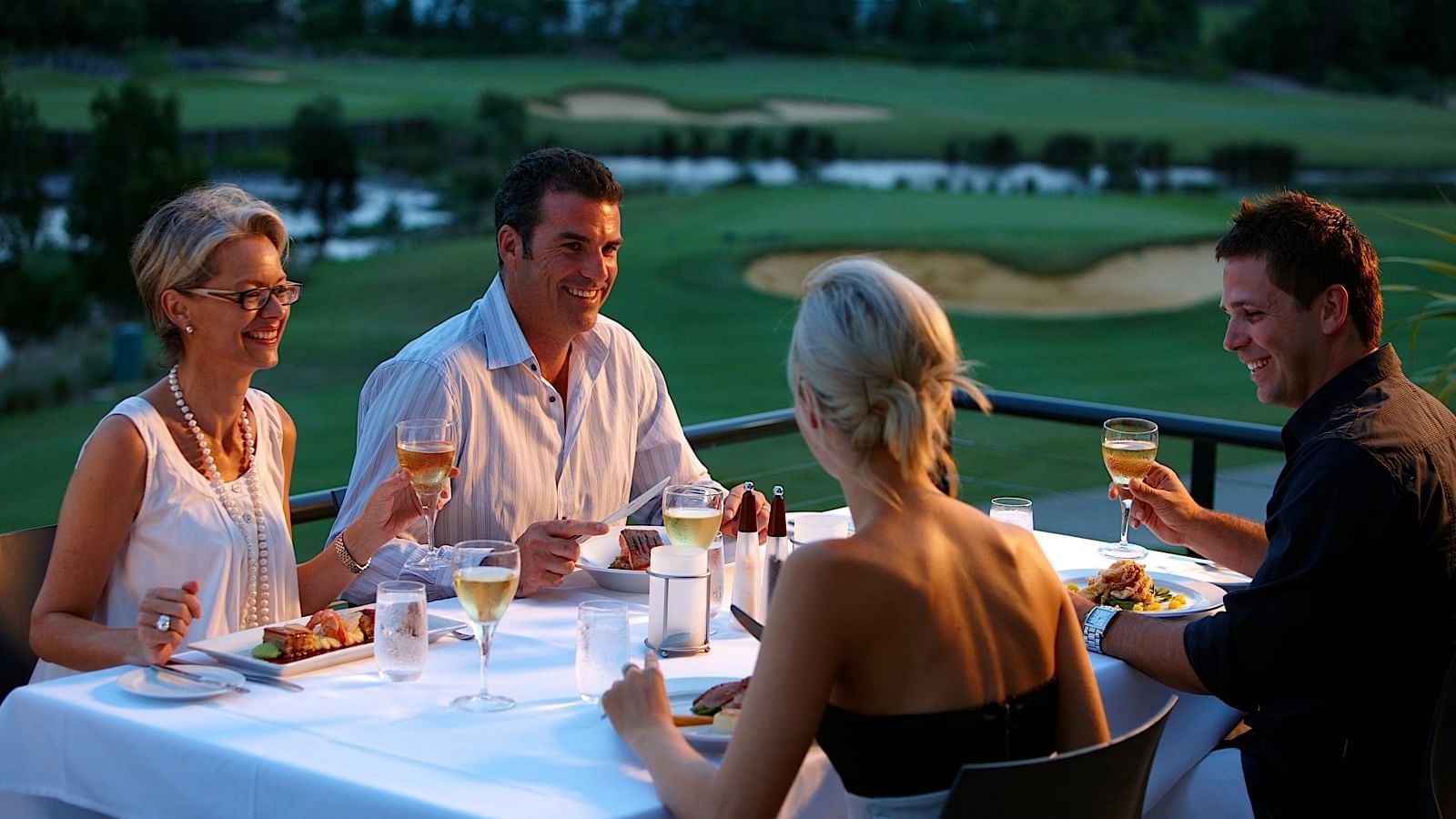 Four people having food in the balcony of Mercure Kooindah Waters hotel