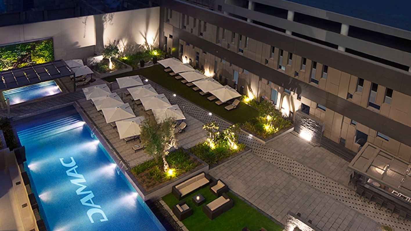 Aerial view of the outdoor lounge area located next to the pool at DAMAC Maison Cour Jardin