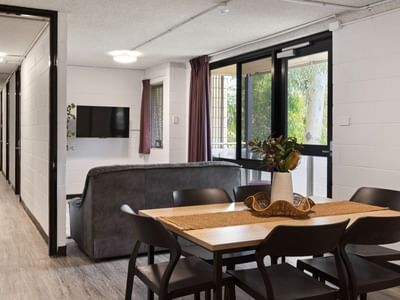 A dining area with a table and chairs and a living area with a couch at UniLodge at Curtin University - Guild House.