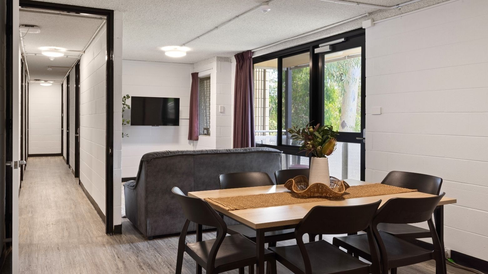 A dining area with a table and chairs and a living area with a couch at UniLodge at Curtin University - Guild House.