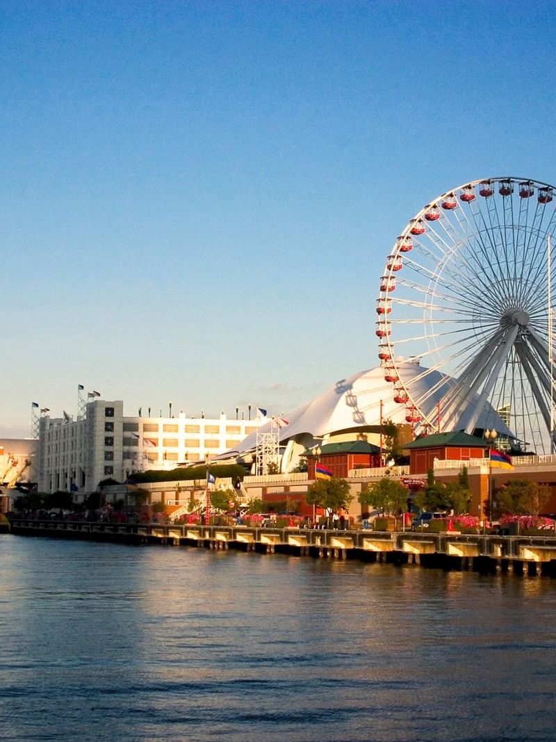 Navy Pier's iconic Ferris wheel and waterfront view with clear blue sky and calm water.