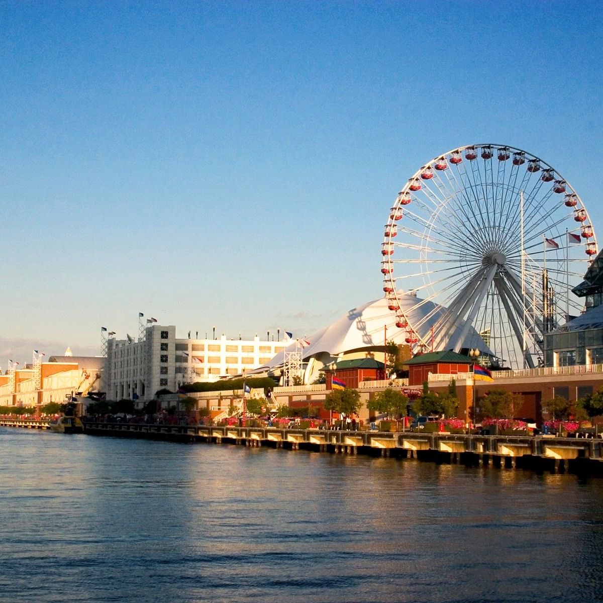 Navy Pier's iconic Ferris wheel and waterfront view with clear blue sky and calm water.