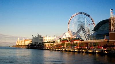 La grande roue emblématique du Navy Pier et la vue sur le front de mer, avec un ciel bleu limpide et des eaux calmes.