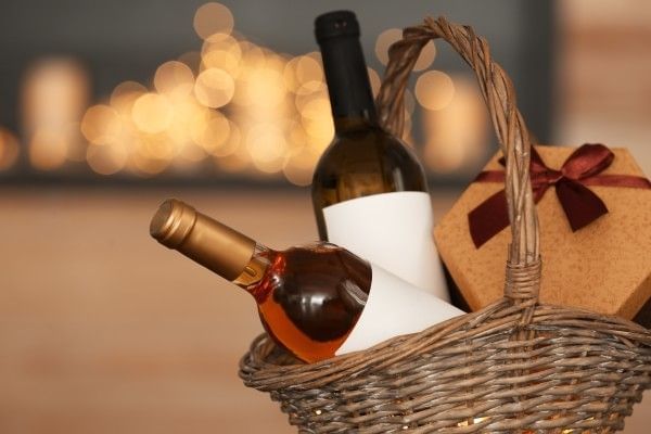 Wicker basket with bottles of wine and gift