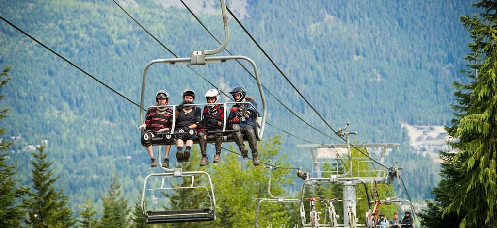 Mountain bikers on a Whistler chairlift heading to downhill trails.
