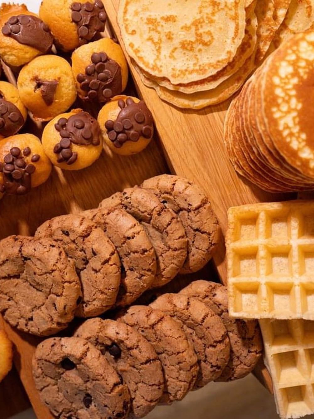 Stacks of pancakes and waffles by chocolate chip muffins and cookies in Sunday Brunch at Warwick Paris Champs Elysées