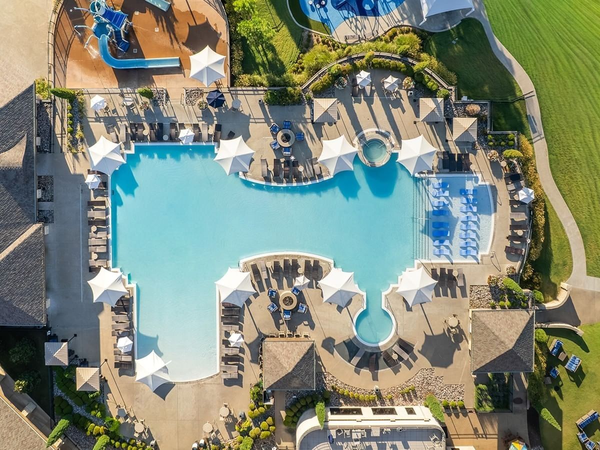 Aerial view of the pool at Shangri-La Resort and Golf Club, with white umbrellas and clear turquoise water