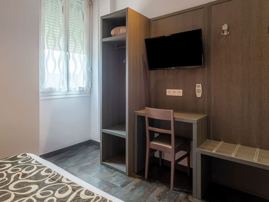 Bedroom with working desk & a TV at The Originals Hotels