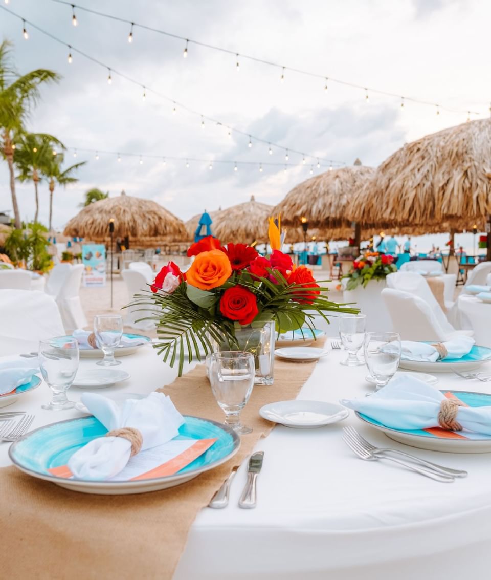 Close-up of beachside dining table arrangement with flower vase at Passions on the Beach