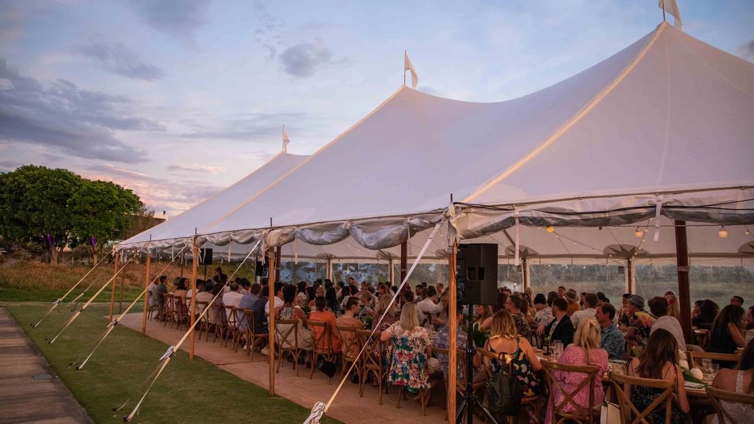 A spacious wedding tent with a crowd at Pullman Magenta Shores