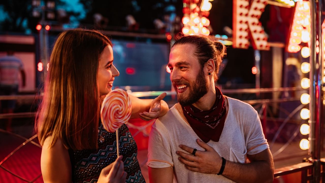 a smiling couple having fun at a night fair