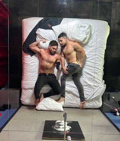 Two guests pose on the bed beneath a mirrored ceiling in the Above The Bar room at The Gaythering