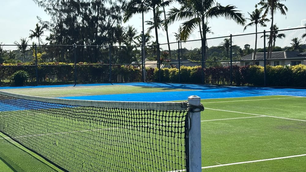 Tennis court with blue and green surface and net at Warwick Le Lagon - Vanuatu in Efate.