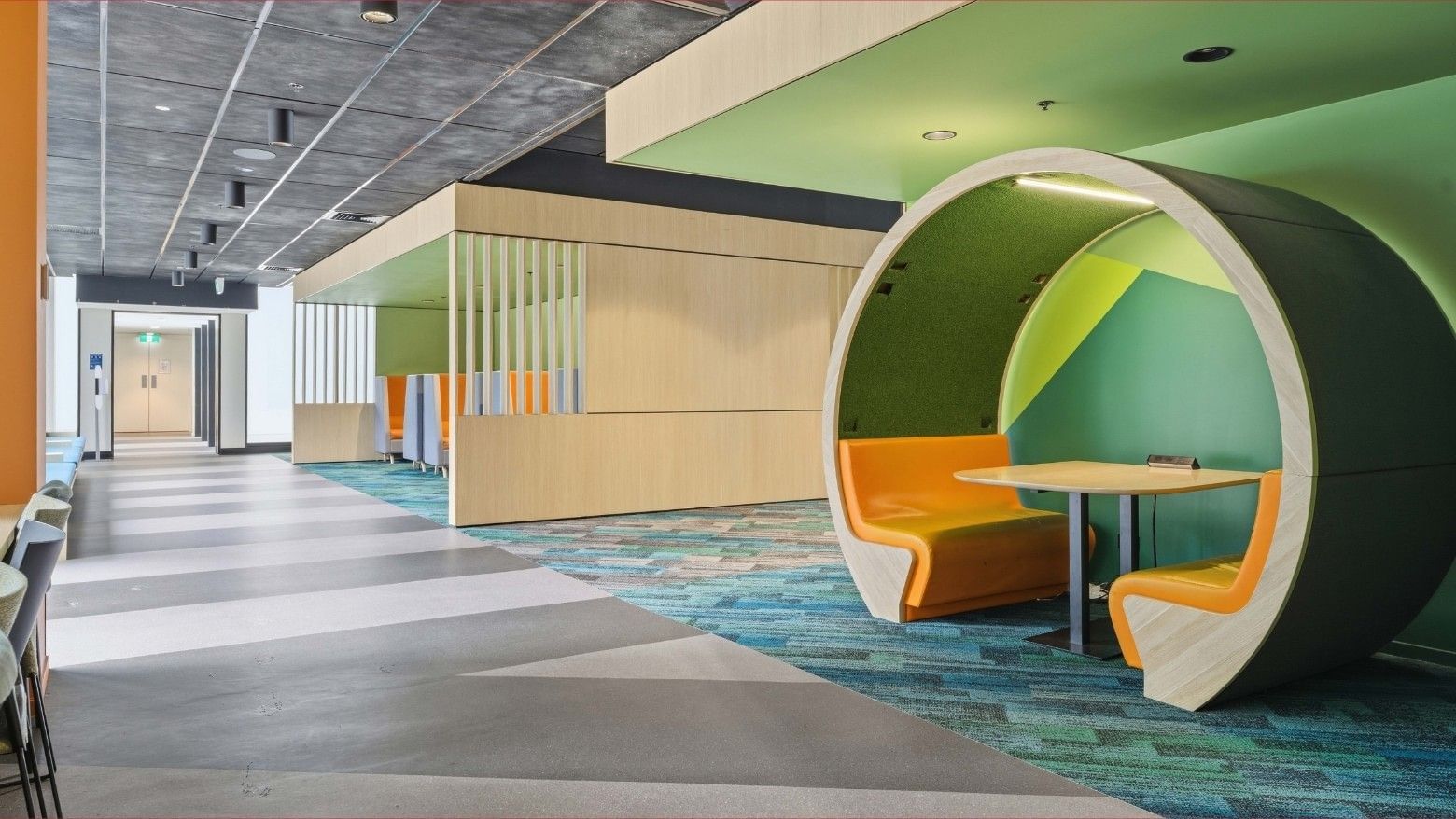 Colorful curved seating area with tables in Mayoral Drive Student Accommodation.