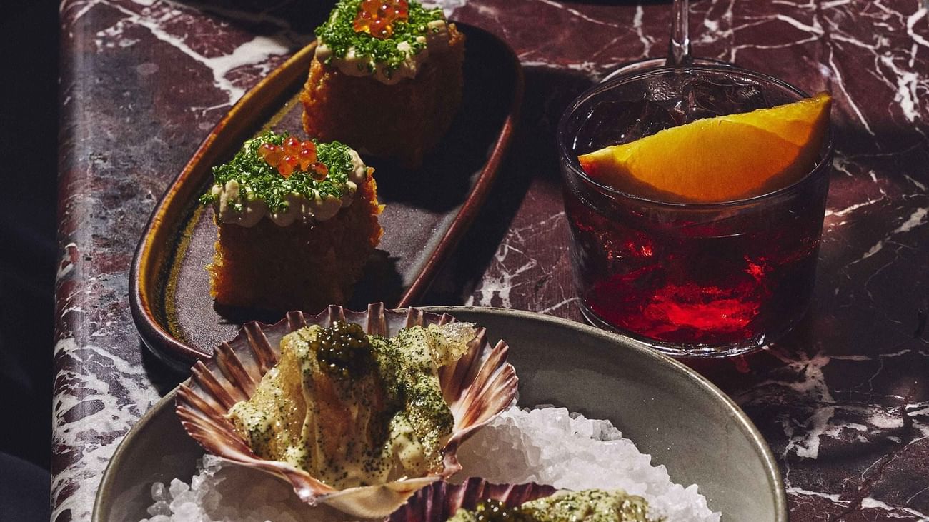 Appetizers and cocktails on a marble table at BAR TILDA, Sofitel Sydney Wentworth.
