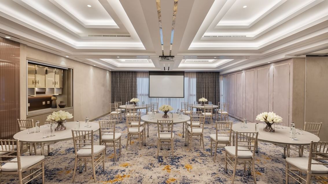 Elegantly set round dining tables with floral centerpieces in Business Studio 1 at Paramount Hotel Midtown