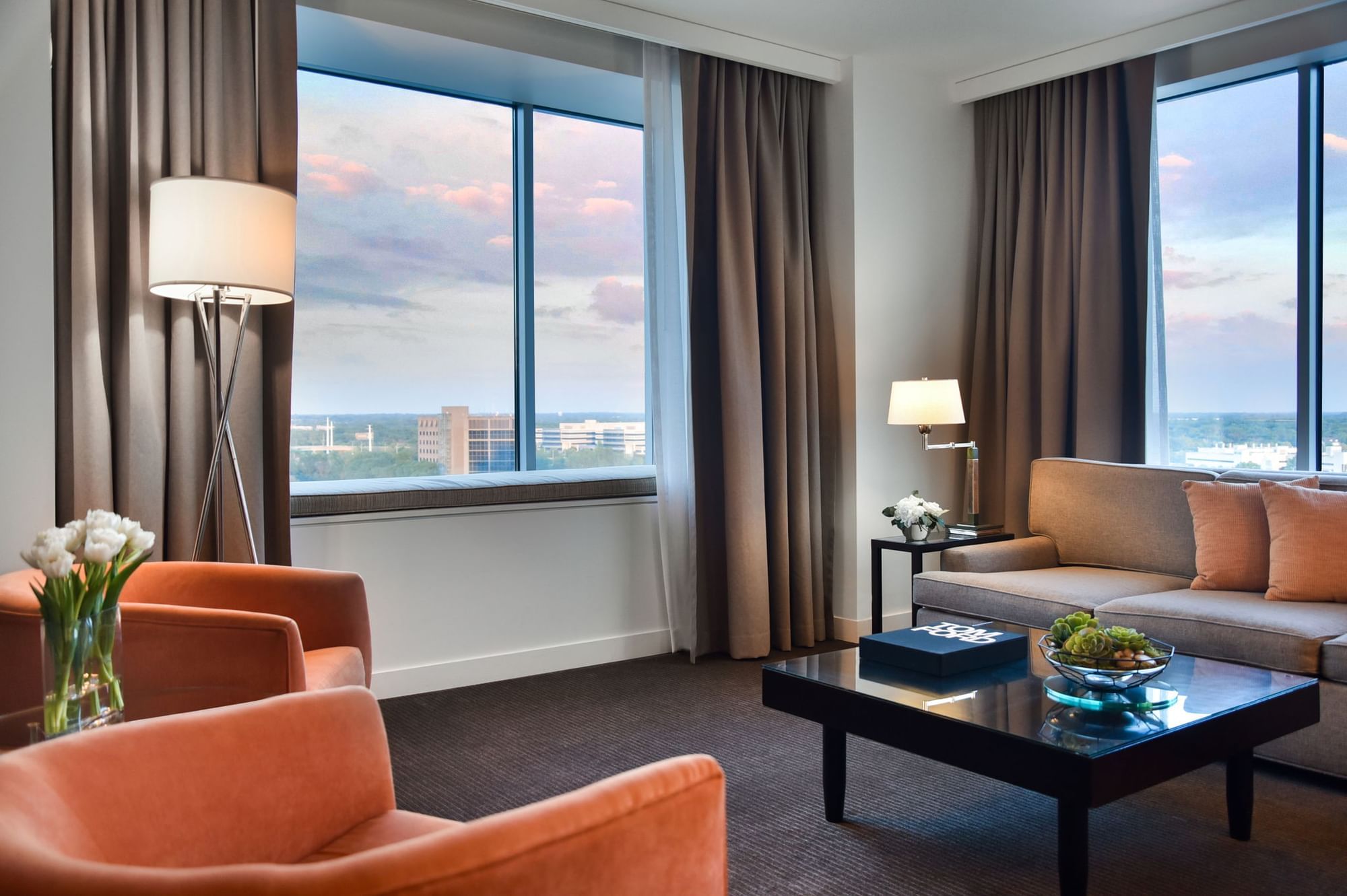 Hotel living area with sofa, chairs, and city view