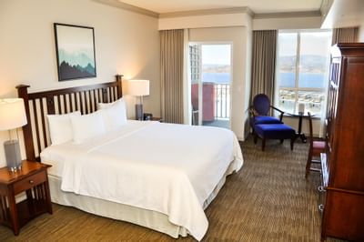Bed, cupboard & chair in a room at Manteo Resort Waterfront