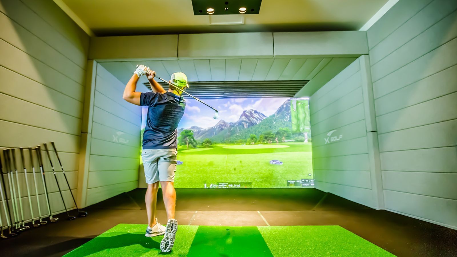 A man playing golf simulator at The Signature Collection