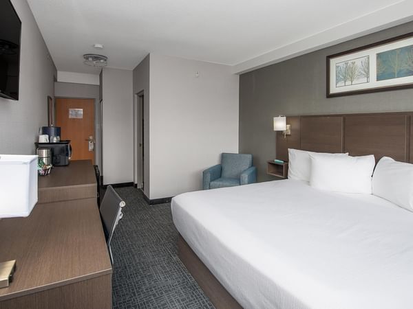 Room with king bed, large desk and chair.