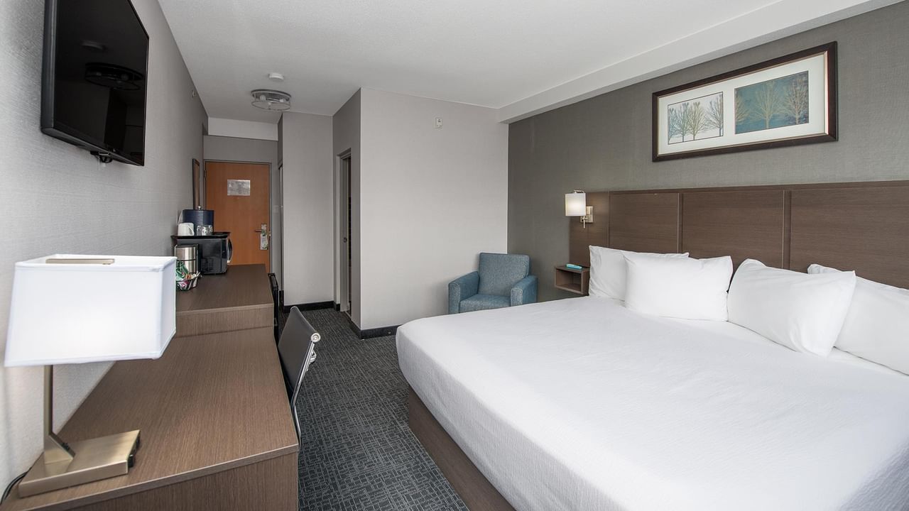 Room with king bed, large desk and chair.