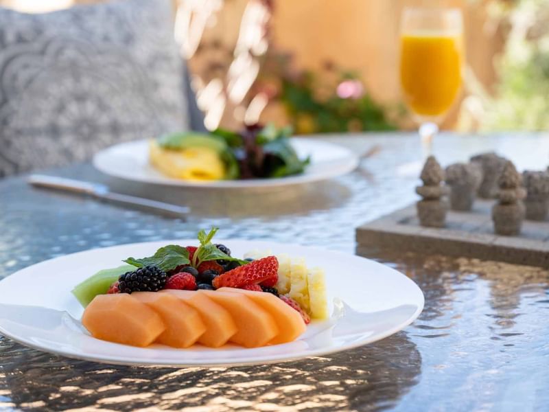 Fresh fruit platter and drinks from the Breakfast in Bed Package at El Prado Hotel, on a patio table
