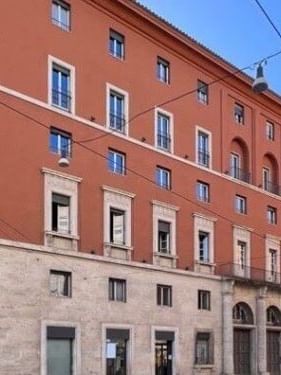 Italian Communist Party headquarters facade with detailed architecture under a blue sky near AG Hotels